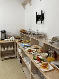 布哈拉Xadijam Hotel的厨房的柜台上放着许多盘子的食物