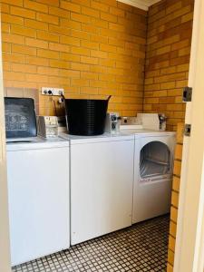 格莱内尔格1BR at Moseley st Glenelg 30的砖墙房里的洗衣机和烘干机