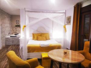 VillamielEscapada Romantica con Bañera y vistas al Castillo de Trevejo的卧室配有一张床和一张桌子及椅子