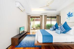 班拉克海滩Bacaya Beachfront Villa的一间卧室配有一张带蓝色枕头的大床