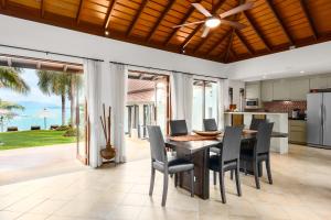 班拉克海滩Bacaya Beachfront Villa的开放式厨房以及带桌椅的用餐室。
