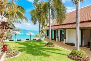 班拉克海滩Bacaya Beachfront Villa的棕榈树和大海的度假村
