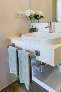 塔拉法尔Oasis Tarrafal Alfandega Suites的一间带水槽和台面毛巾的浴室