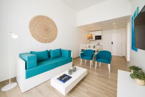塔拉法尔Oasis Tarrafal Alfandega Suites的客厅配有蓝色的沙发和桌子