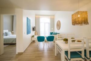 塔拉法尔Oasis Tarrafal Alfandega Suites的配有一张床和一张桌子及椅子的房间