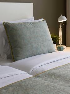 塔拉法尔Oasis Tarrafal Alfandega Suites的床上有绿色枕头