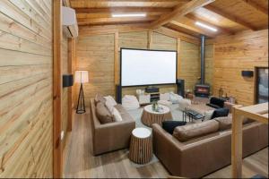 布勒山AALFOR LODGE - Luxury Cabin with Spa & Cinema!的带沙发和大屏幕的客厅