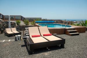 马赫Finca Isolina Hotel Boutique - Adults Recommended的游泳池畔的2把躺椅