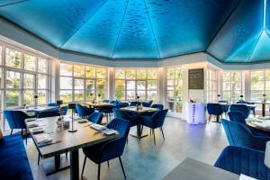 基姆湖畔普林Yachthotel Chiemsee GmbH的餐厅拥有蓝色的天花板和桌椅