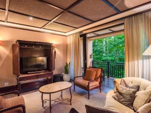 巴利托Zimbali Lodge by Dream Resorts的客厅配有电视、沙发和椅子