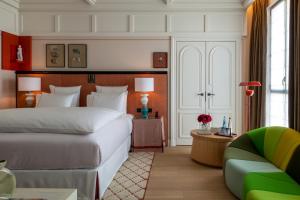 巴黎Sinner Paris的卧室配有一张白色的大床和一张沙发。
