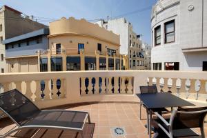 瓦伦西亚加泰罗尼亚伊克赛尔瑟酒店的一个带桌椅的阳台和一座建筑