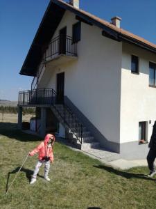 新瓦罗什Apartman Teodora Uvac的一名在建筑物前玩风筝的小孩