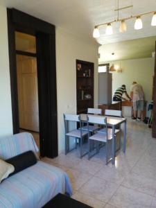 阿罗纳Primavera appartement tot 7 personen的客厅配有桌椅,可供住客使用