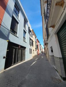 马拉加Romántico Estudio con Piscina的建筑物之间的小巷里一条空的街道