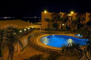 延布Alahlam Resort Yanbu的夜间在房子前面的游泳池