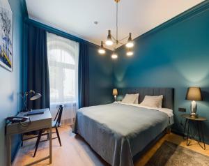 里加Aparthotel Amella的一间卧室设有蓝色的墙壁、一张床和一张书桌