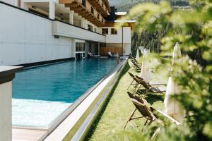 萨尔巴赫瑟纳尔霍夫酒店的一个带躺椅的游泳池和一个游泳池