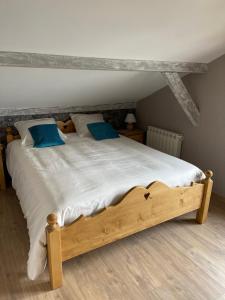 MontperreuxCHALET-MICHEL avec SPA的一间卧室配有一张带蓝色枕头的木床。