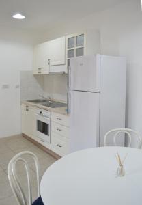 布德瓦Eco Village Buljarica的厨房配有白色橱柜和白色冰箱。