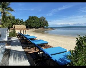 班邦宝Nam Jai Beach - Sunset的海滩上一排蓝色的桌椅