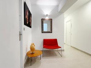 卡沃内拉斯Hostal Las Palmas的走廊上的红色椅子和桌子