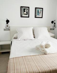 卡沃内拉斯Hostal Las Palmas的一间卧室配有一张床,上面有两条毛巾