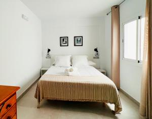 卡沃内拉斯Hostal Las Palmas的白色卧室配有一张带毯子的床
