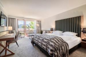 施塔费尔湖畔穆尔瑙穆尔瑙阿尔班霍夫酒店_x000D_的酒店客房设有一张大床和一张书桌。