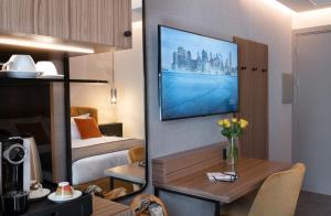 伊夫雷亚3T Boutique Hotel的酒店客房设有一张床和一张带电视的书桌。