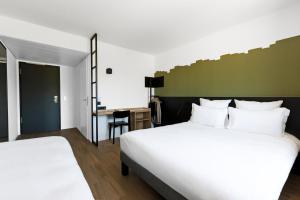 尼翁B&B HOTEL Nyon的酒店客房配有两张床和一张书桌