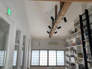 京都Gion Jizo的一间设有书架和大窗户的房间