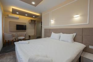 斯科普里Hotel & Resort Bon Bon的卧室配有一张白色大床和电视。