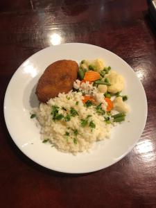 Naujoji AkmenėHotel Akmenė的饭,鸡和蔬菜的盘子