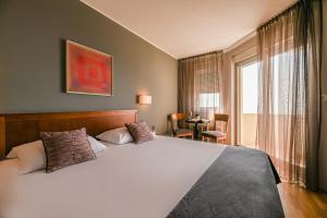 奥帕提亚Hotel Laurus - Liburnia的卧室设有一张白色大床和一扇窗户。