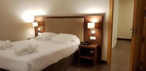 埃尔戈里亚加巴尔纳里奥厄尔格利伽酒店的卧室配有一张带白色床单和枕头的大床。