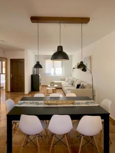 LanzahitaEl Escondite de Gredos的客厅配有桌子和白色椅子