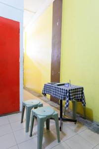JodohSPOT ON 91512 Siantan Anambas Syariah的桌子和椅子的房间的桌子和凳子