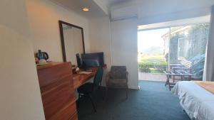 姆巴巴内Mountain View International by BON Hotels的酒店客房设有一张桌子、一张床和一个窗户。