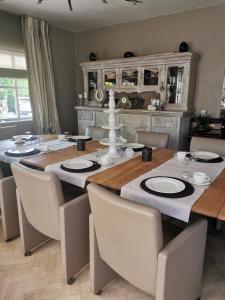 拉纳肯Bed & Bokes aan de Maaskant的用餐室配有带椅子的大木桌
