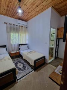 吉诺卡斯特B Vishe Guest House的一间大卧室,配有两张床和镜子