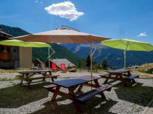 凯拉地区莫利讷Chalet le Genepy with amazing views!的山顶上两张带雨伞的野餐桌