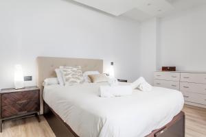 瓦伦西亚CASA ESPECTACULAR DE DISEÑO CON JARDIN INTERIOR的一间白色卧室,配有两张床和床头柜
