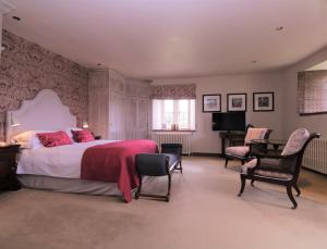 梅德斯通Leeds Castle Maiden's Tower的一间卧室配有一张大床和一架钢琴
