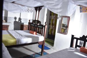 NgamboBABAbora house的一间卧室配有一张带天蓬的床