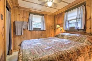 SanborntonLake Hermit Cabin with Kayaks and Paddleboards!的卧室配有木墙和窗户。