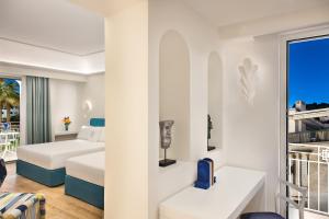 卡普里Pazziella Garden & Suites的酒店客房设有两张床和一个阳台。
