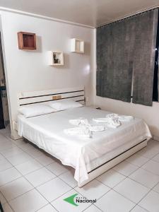 阿拉皮拉卡Hotel Nacional的一间卧室配有一张带白色床单的床和一扇窗户。