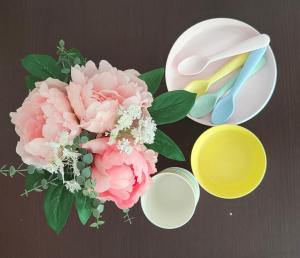 马德里Apartamento familiar的一张桌子,上面放着一束粉红色的花,还有一碗和汤匙