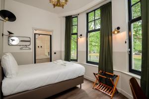 鹿特丹Mr.Lewis Rotterdam的一间卧室配有床、窗户和椅子